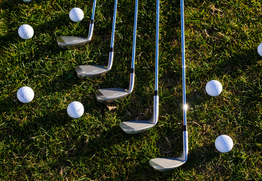 Golf Clubs and Golf Balls laid out on the green waiting for personalisation.