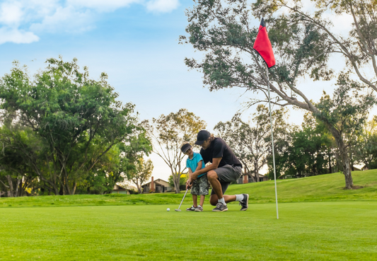 Father's day on the Golf Green, with a father showing his son how to play